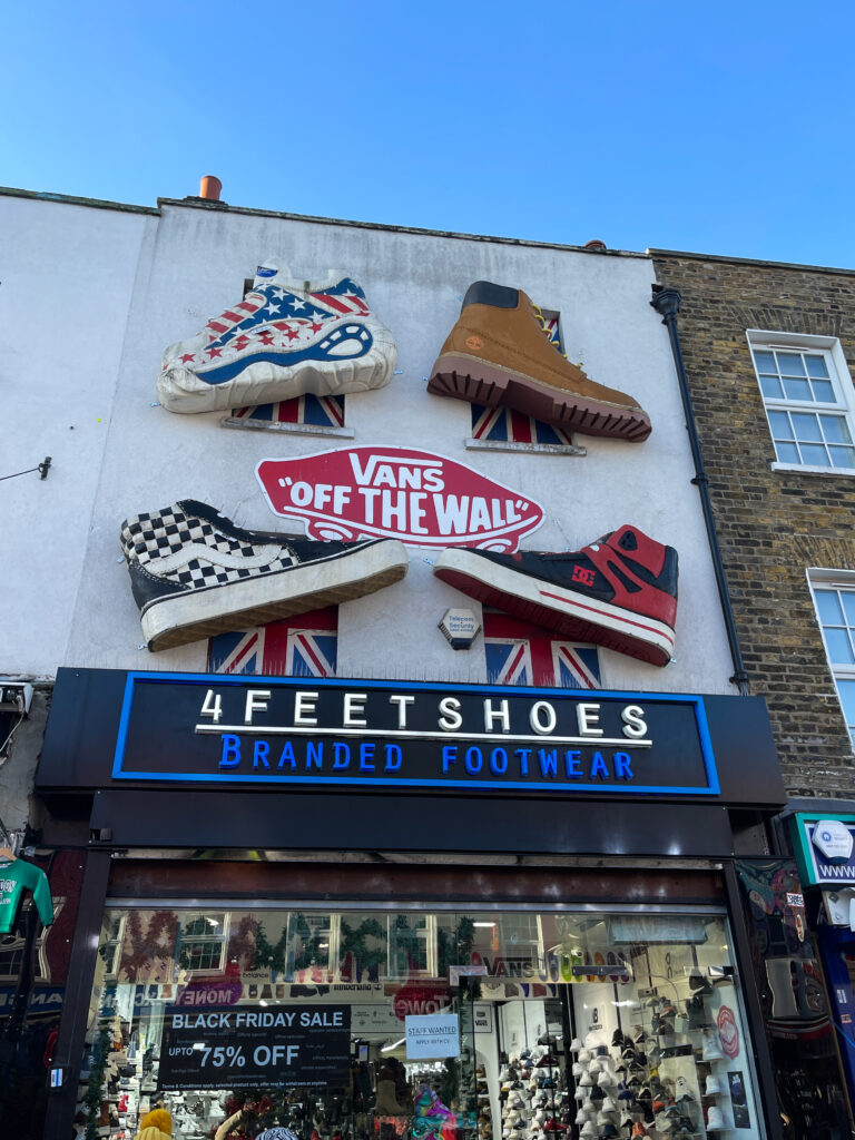 un magasin de chaussure, avec une vitrine, l'enseigne et des chaussures en décorations