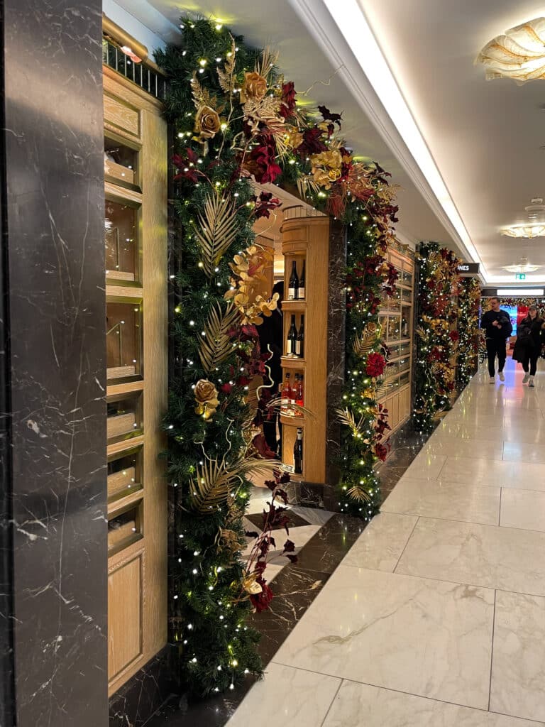 intérieur du magasin harrods avec décorations de noel, des fleurs