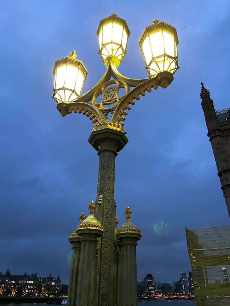 un lampadaire avec trois lumières, la nuit, avec le fond la ville