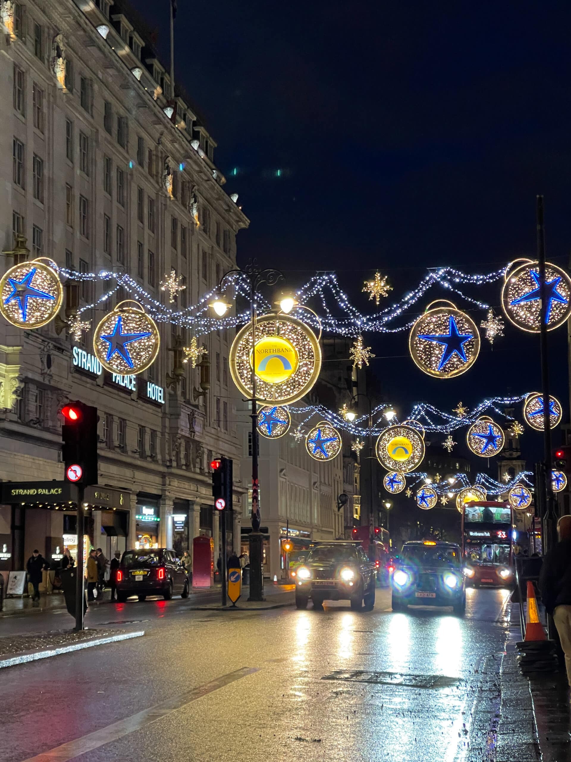 londres le soir avec les illuminations de noël, des voitures, bus rouge