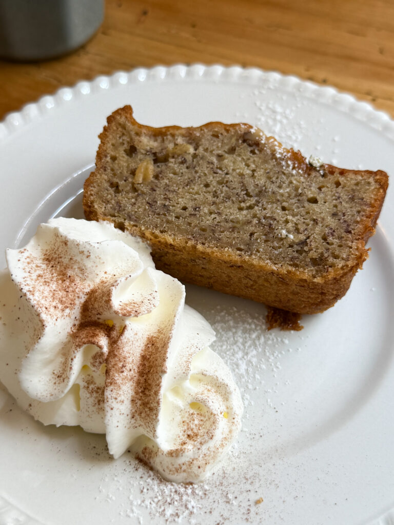 une assiette avec un banana bread, et chantilly